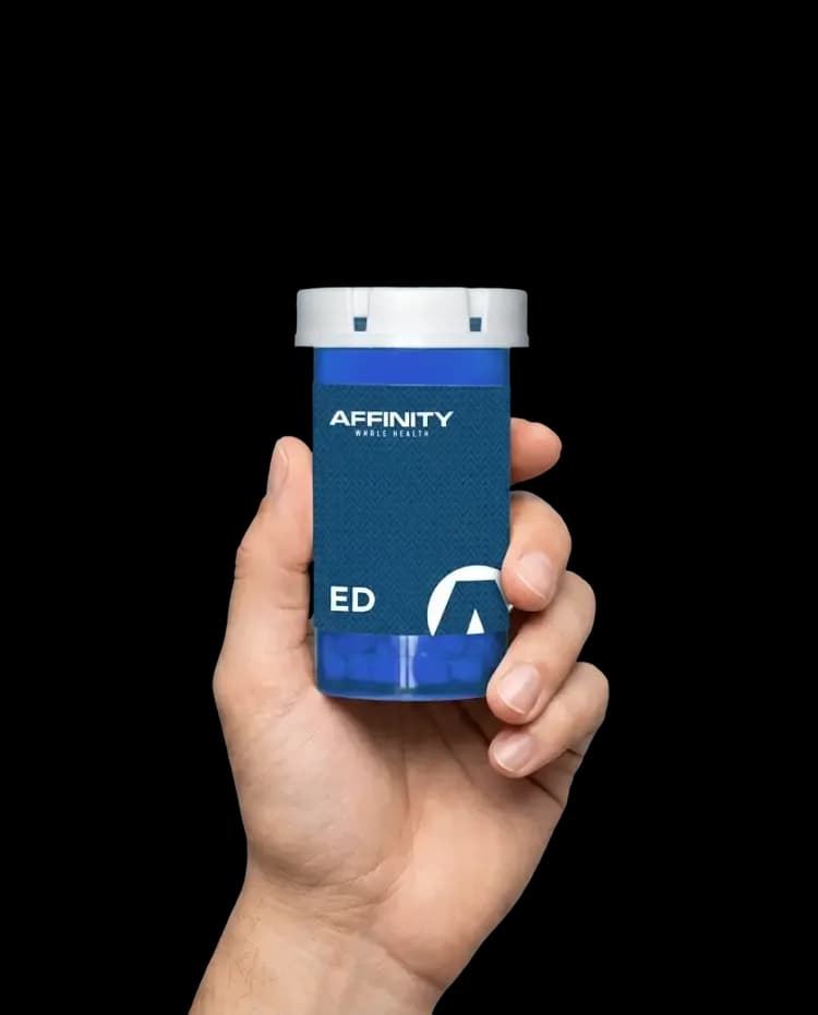 A hand holding an Affinity ED treatment bottle