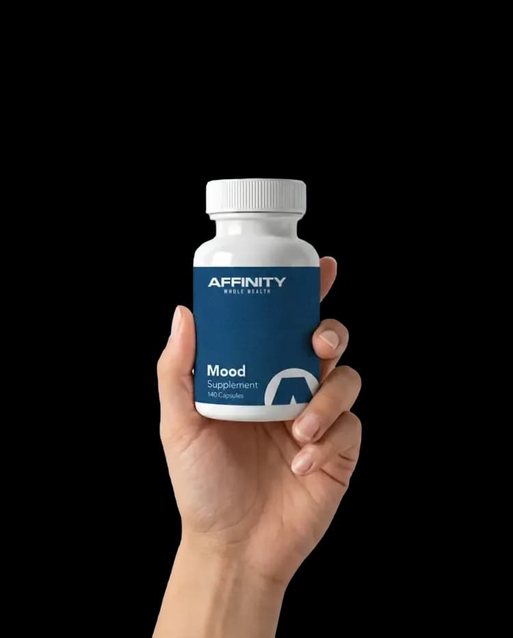 A hand holding an Affinity Mood supplement bottle